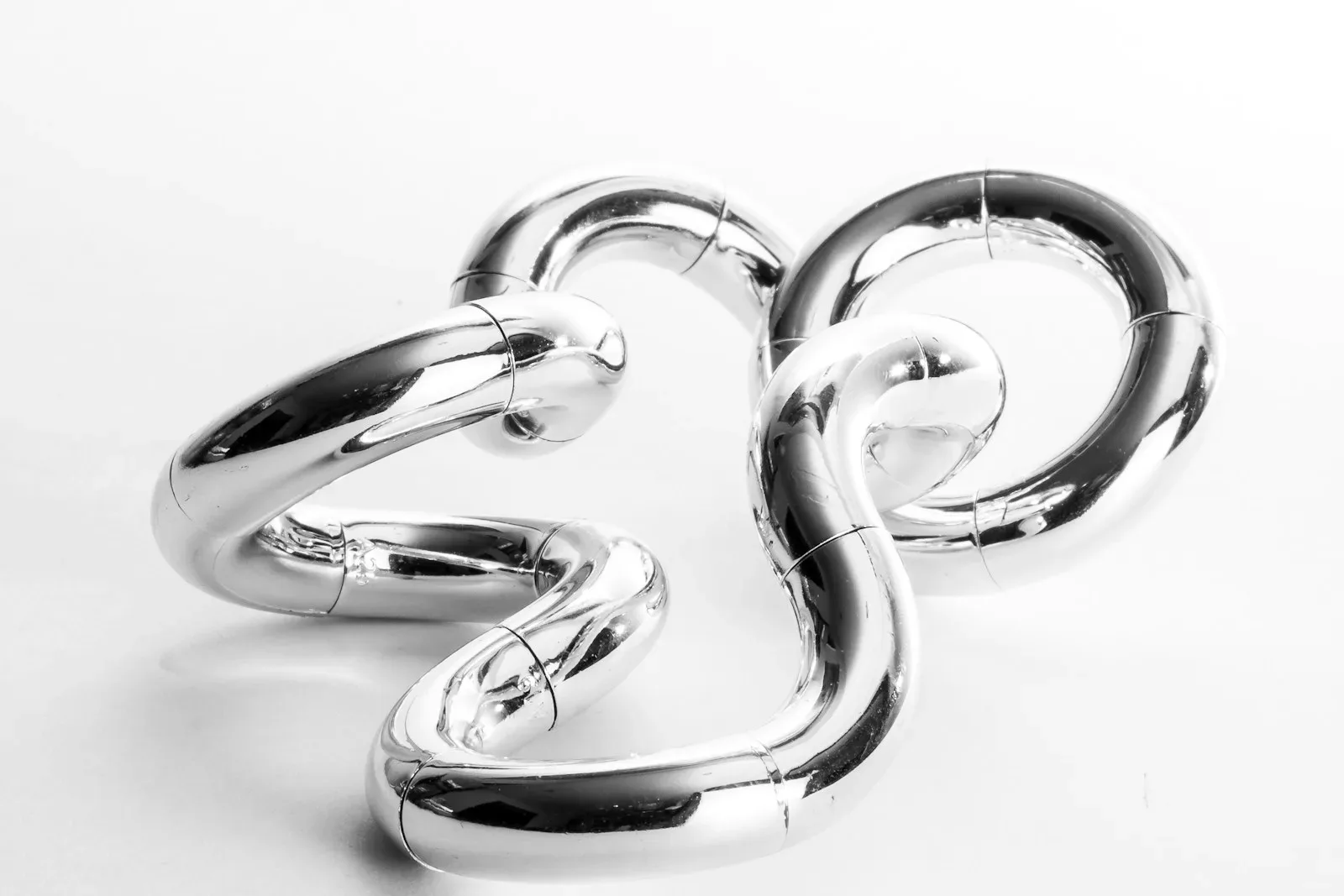 a shiny metal object on a white surface